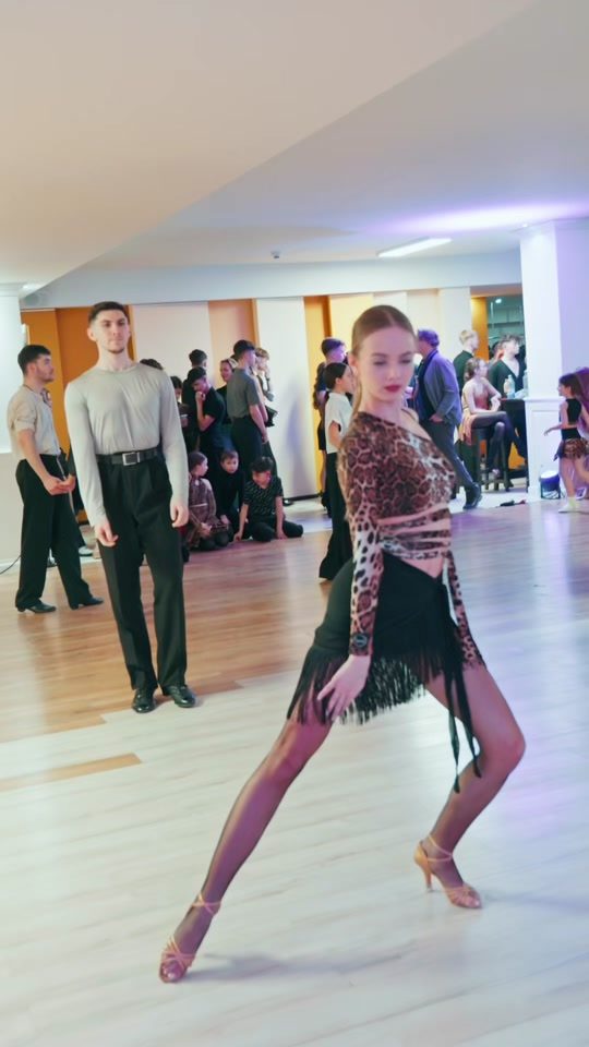 Un cuplu dansând un dans latino elegant în rochie teal — rumba